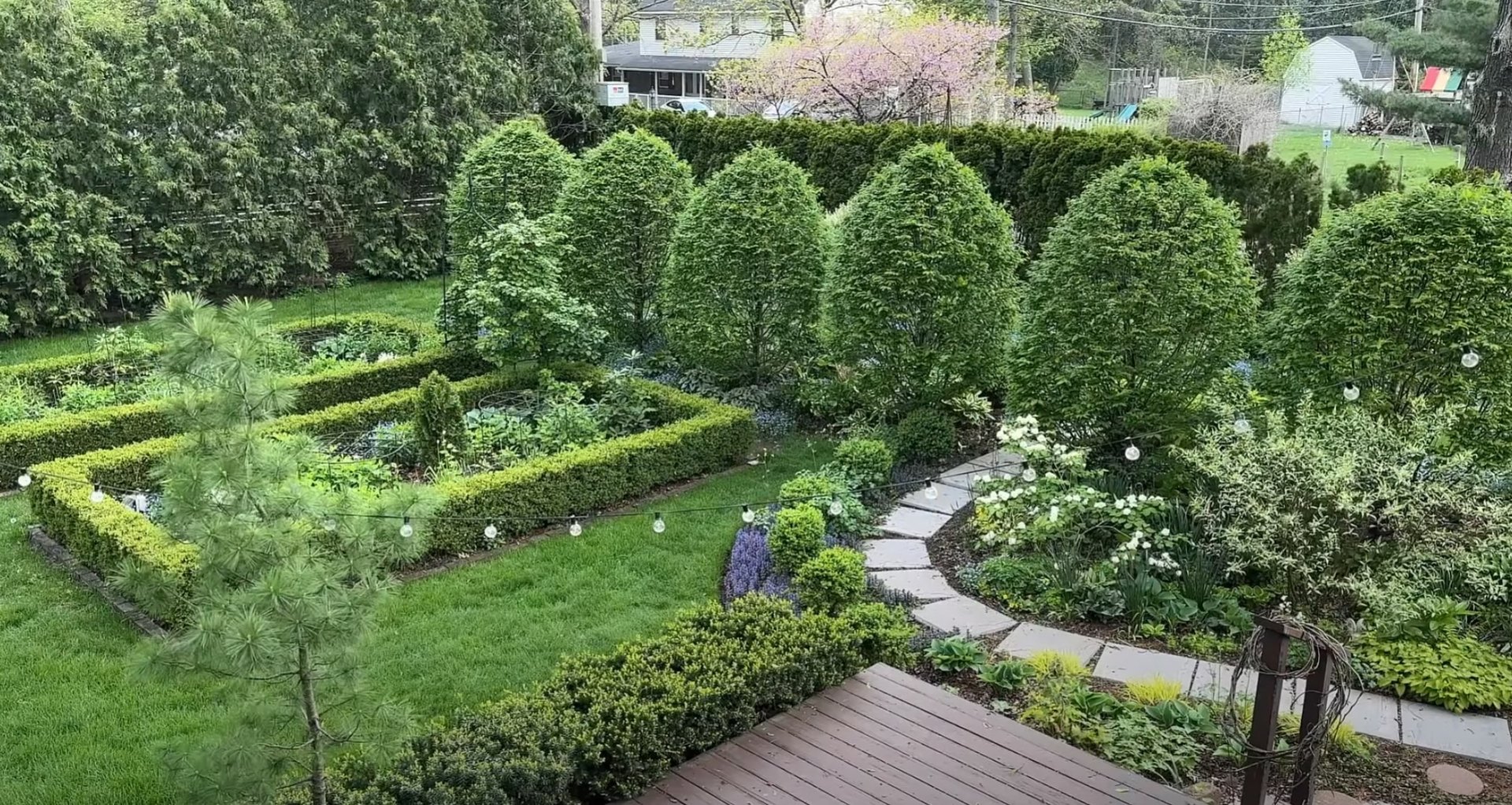 Formal garden landscape with geometric lawn patterns, hedged borders, and professional hardscaping elements